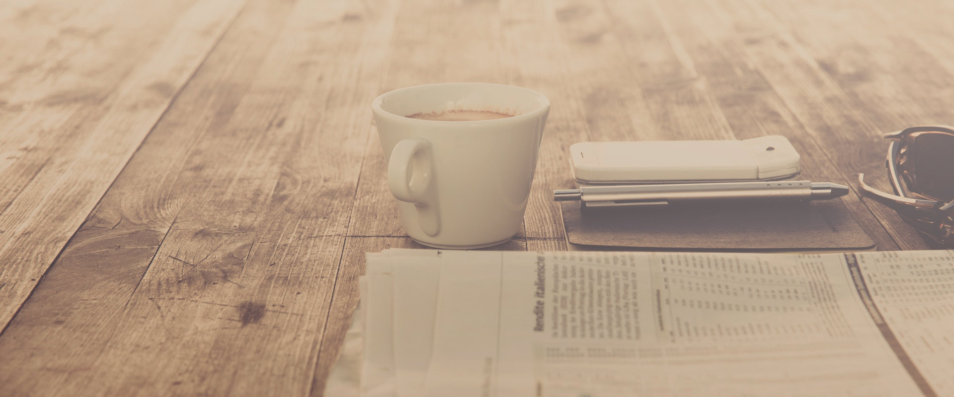 Tisch mit Zeitungen und Kaffeetasse